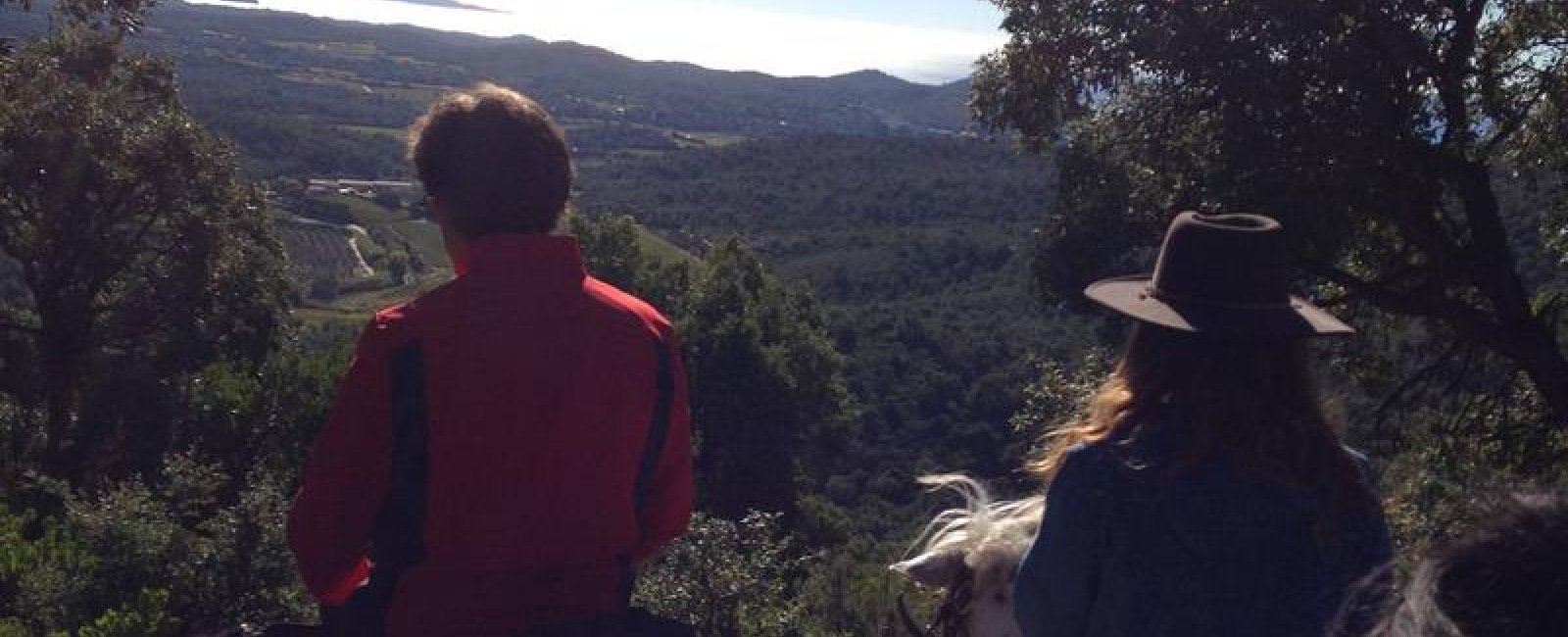 Cavaliers observant le panorama des collines de Pierrefeu avec la vue sur la mer au dernier plan
