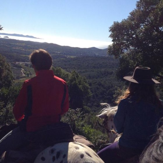 Cavaliers observant le panorama des collines de Pierrefeu avec la vue sur la mer au dernier plan
